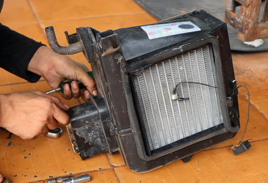 Technician removing car broken car evaporator